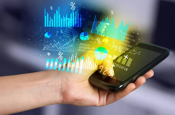 Ruka držící smartphone s obchodní diagramy — Stock fotografie