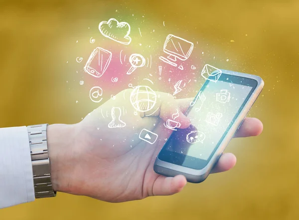 Hand holding smartphone with media icons — Stock Photo, Image