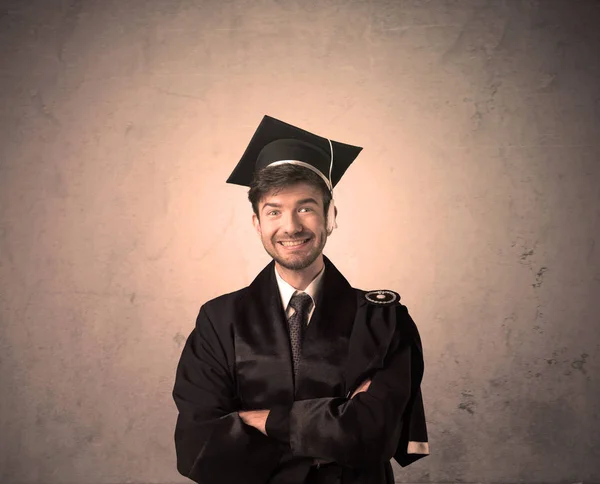 Retrato de un joven estudiante graduado con antecedentes gruñones — Foto de Stock