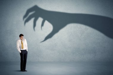 İş kişi büyük canavar pençe gölge kavramı korkuyor