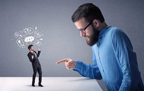 Young businessman fighting with miniature businessman — Stock Photo, Image