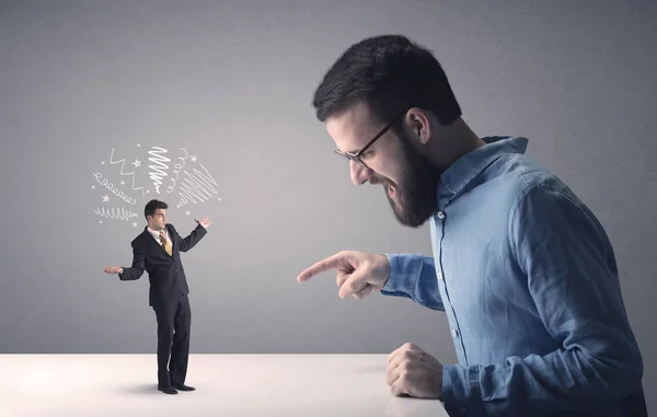 Young businessman fighting with miniature businessman — Stock Photo, Image