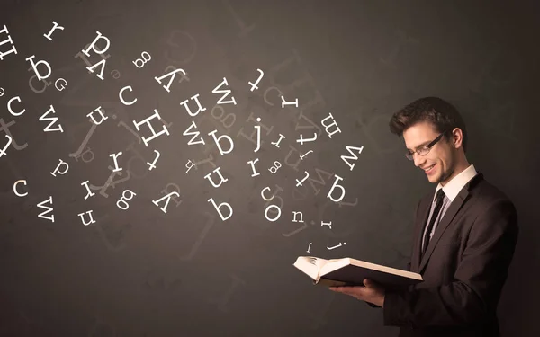 Jovem segurando livro com letras — Fotografia de Stock