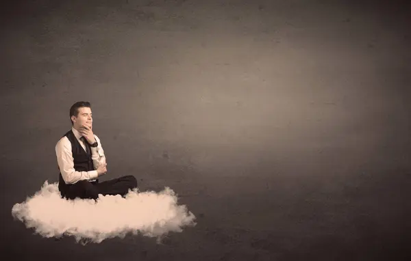 無地の背景で雲の上に座っている男 — ストック写真