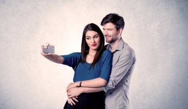 Mutlu çift temiz duvarlı selfie çekiyor.
