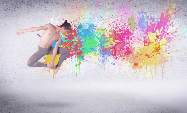 Moderno ballerino di strada che salta con schizzi di vernice colorata — Foto Stock