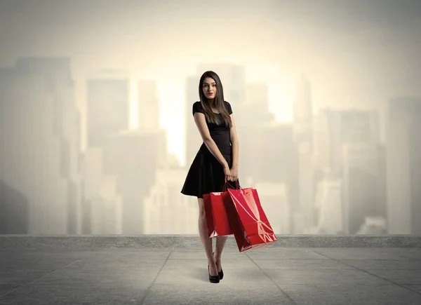 Elegante ragazza di città con borse della spesa rosse — Foto Stock