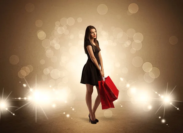 Shopping lady con borse in luci brillanti Immagine Stock