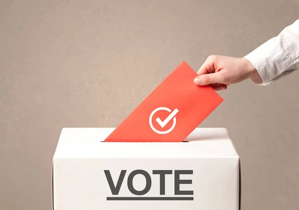 Close up of male hand putting vote into a ballot box