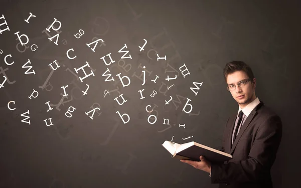 Jovem segurando livro com letras — Fotografia de Stock