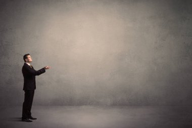 Boş bir duvarın önünde, ayakta işadamı