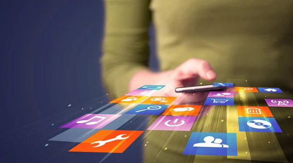 Woman holding smart phone with colorful application icons — Stock Photo, Image