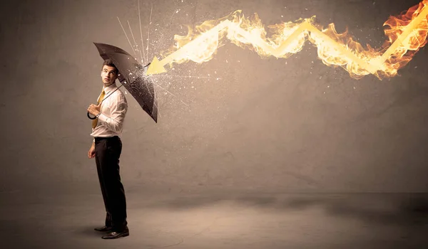 Business man defending himself from a fire arrow with an umbrell — Stock Photo, Image