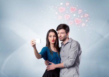 Aşık çift kırmızı kalple selfie çekiyor.