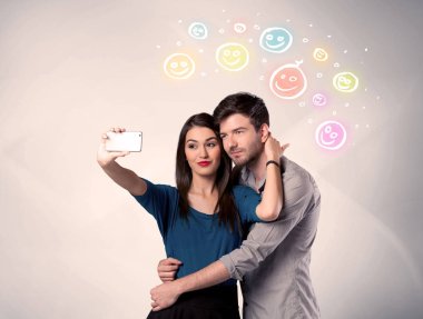 Mutlu çift gülen yüzle selfie çekiyor.