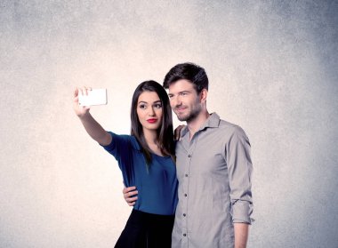 Mutlu çift temiz duvarlı selfie çekiyor.