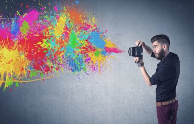Kamera ve boya sıçratan hippi adam.