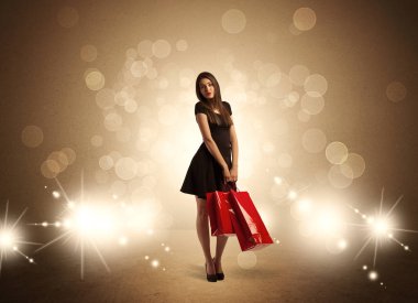 Parlak ışıklarda çantalı alışveriş yapan kadın.