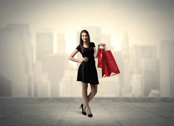 Elegant stadsmeisje met rode boodschappentassen — Stockfoto