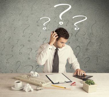 İş adamı soru işaretiyle masada.