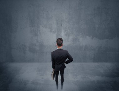 Şehir duvarının önünde duran iş adamı