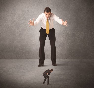 Büyük iş adamı küçük işçilere bakıyor.