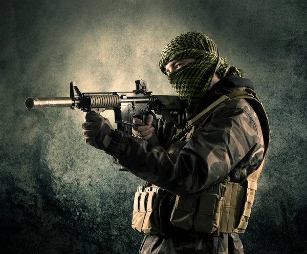 Porträtt av en tungt beväpnade maskerade soldat med grungy bak — Stockfoto