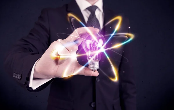 Businessman holding a colorful light bulb — Stock Photo, Image