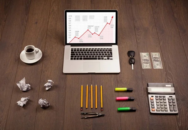 Mesa de computador com laptop e gráfico de seta vermelha na tela — Fotografia de Stock