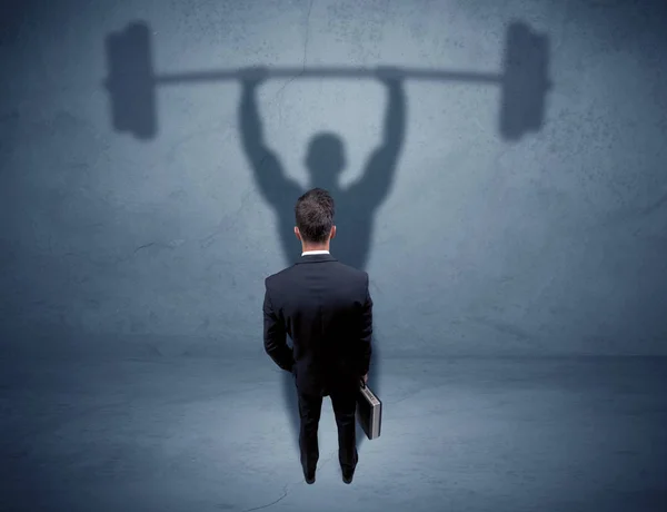 Businessman with weight lifting shadow — Stock Photo, Image