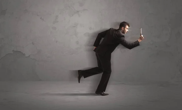 Running businessman with device in hand — Stock Photo, Image