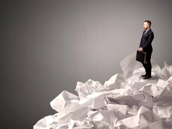 Businessman standing on crumpled paper — Stock Photo, Image