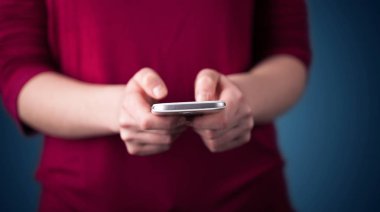 Akıllı telefonu elinde tutan genç bir kadın. 