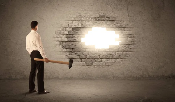 Business man hitting brick wall with hammer and opening a hole — Stock Photo, Image