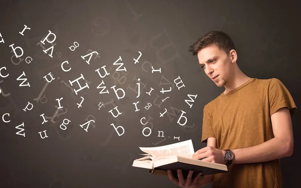 Jovem segurando livro com letras — Fotografia de Stock