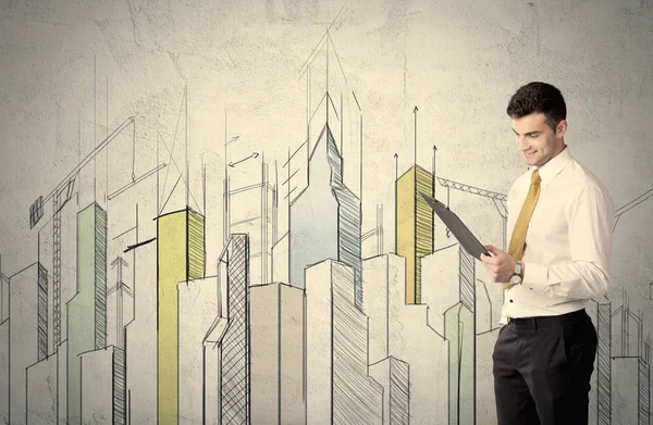 Businessman standing with drawn cityscape — Stock Photo, Image