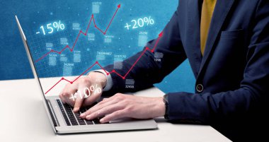 Satıcı dizüstü bilgisayarla grafikle çalışıyor.