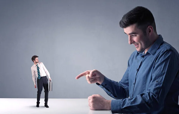 Young businessman fighting with miniature businessman — Stock Photo, Image