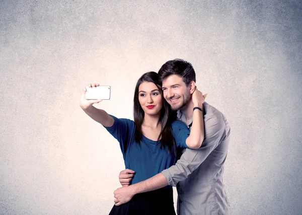 Felice coppia prendendo selfie con parete chiara — Foto Stock