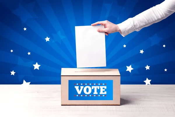 Main avec bulletin de vote et boîte en bois — Photo