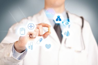 Beyazlı bir doktor elinde hap tutuyor.