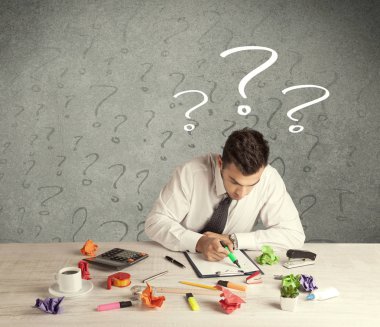 İş adamı soru işaretiyle masada.