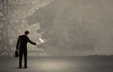 Satış elemanı duvardaki tabloların üstünü boyuyor.