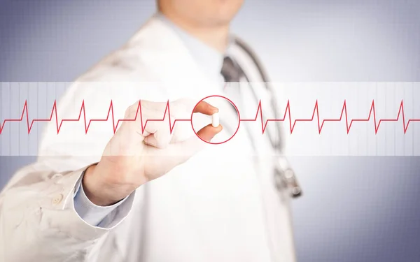 A doctor  holding a heart pill — Stock Photo, Image