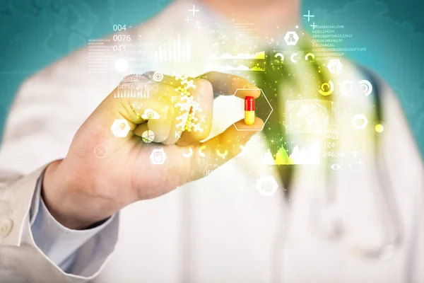 Doctor holding a pill between fingers — Stock Photo, Image