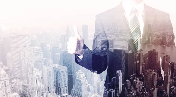 İş adamı çatıda duruyor ve arka planda şehir var.