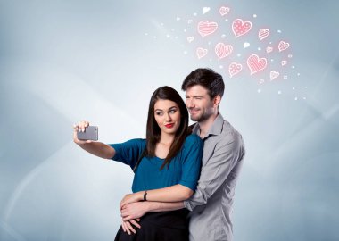 Aşık çift kırmızı kalple selfie çekiyor.