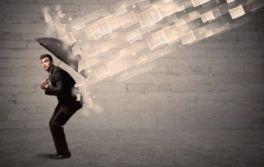 İş adamı ile şemsiye kağıtları rüzgara karşı koruma
