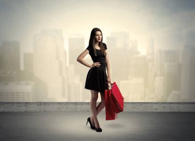 Alışveriş torbalarıyla duran şehir kadını.