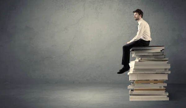 Elegante macho sentado en los libros —  Fotos de Stock